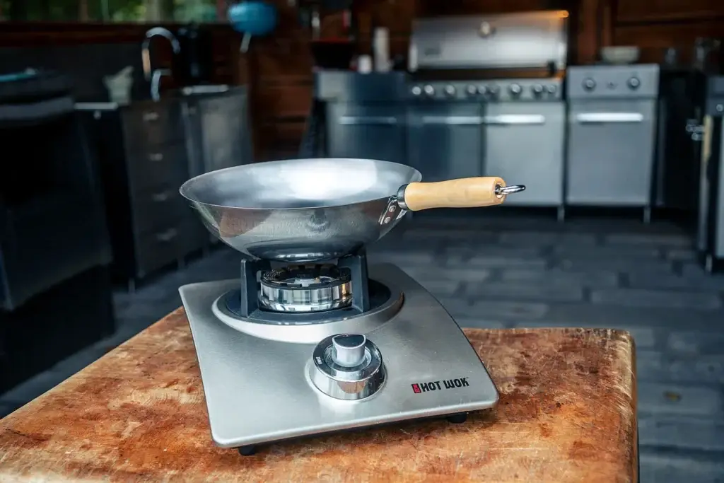 Steel wok on a wooden kitchen table