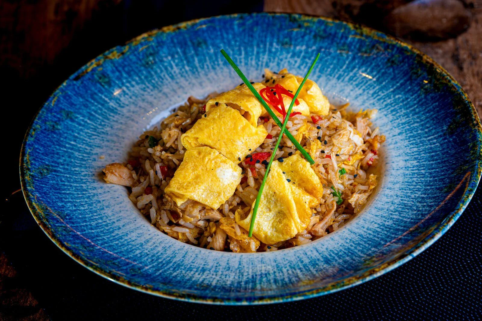 Egg fried rice garnished with herbs and chilli