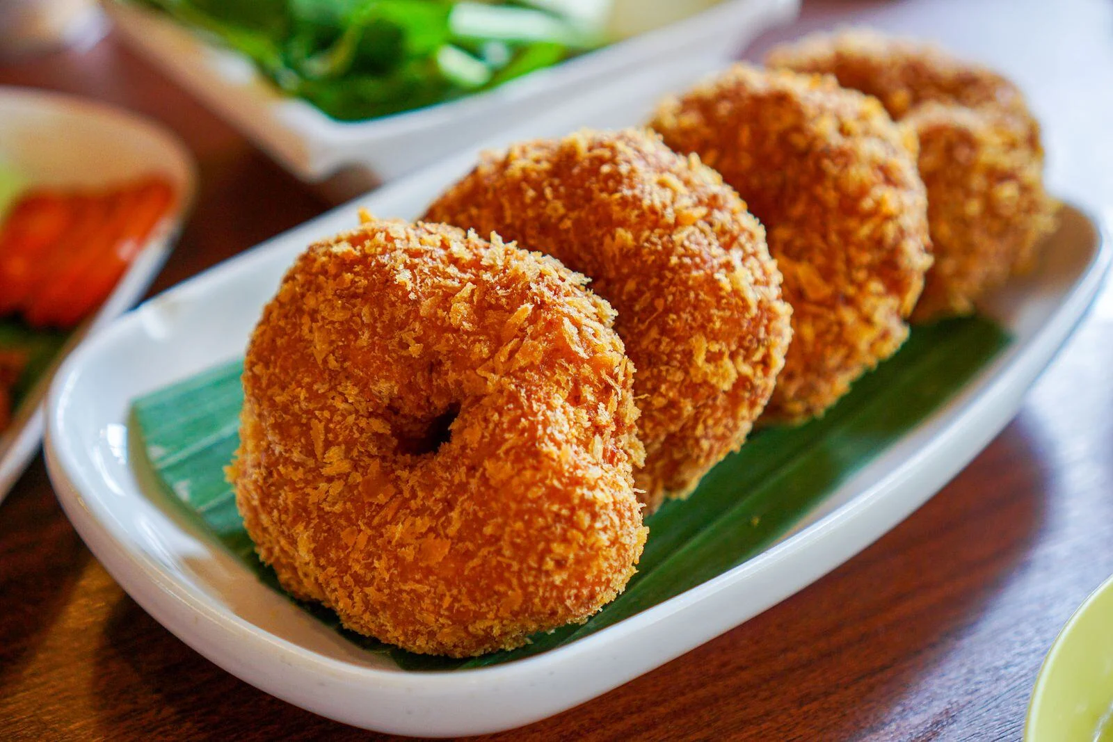 Fried prawn toast pieces served on a banana leaf platter