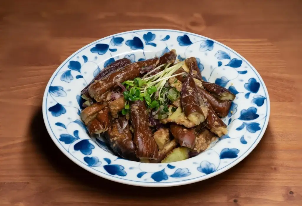 Sticky Asian aubergine dish on a blue floral plate