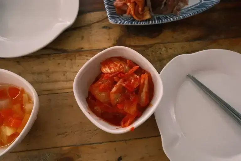 Korean kimchi in a white bowl on a wooden table