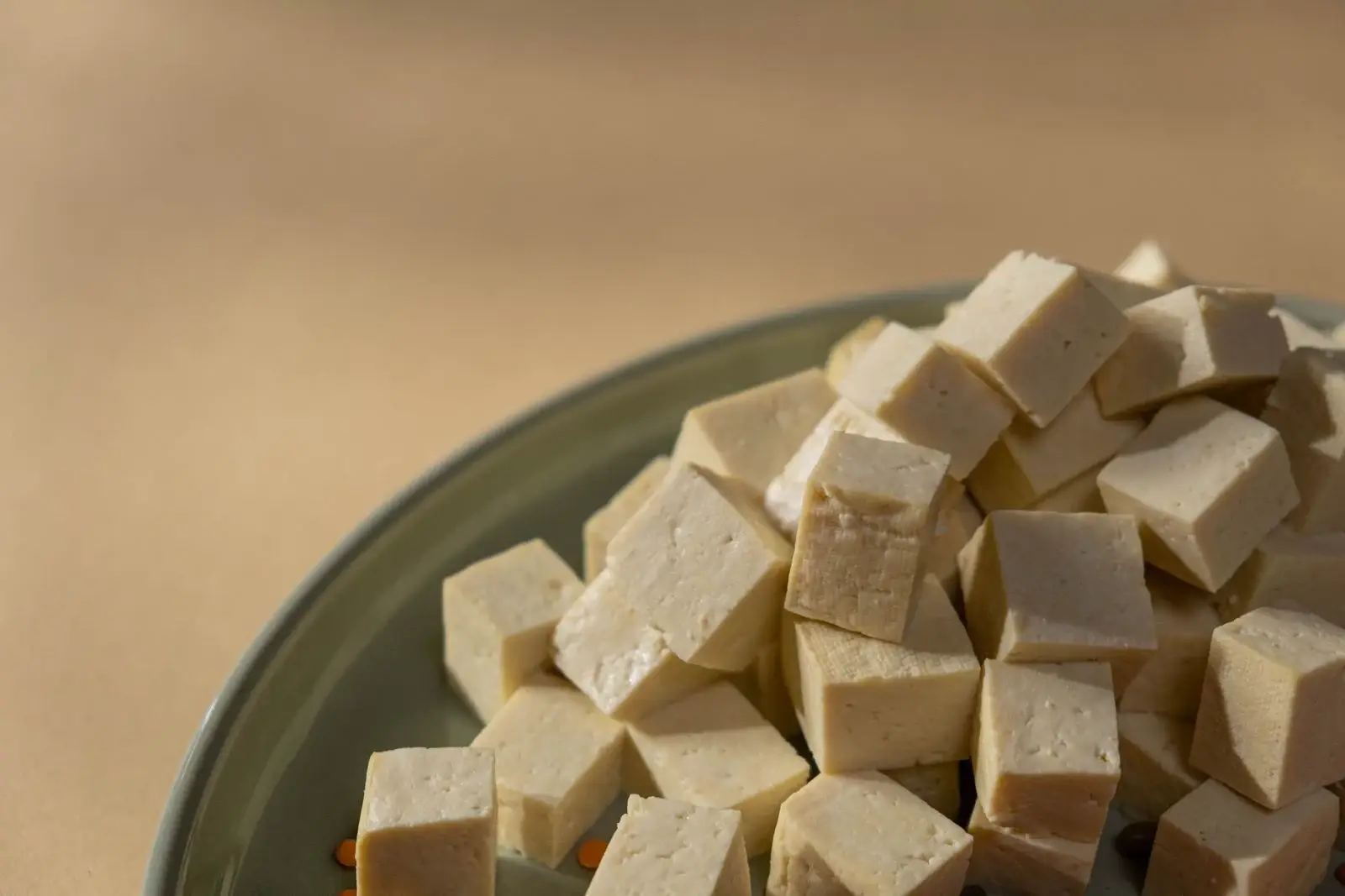 Cubes of fresh tofu on a green plate